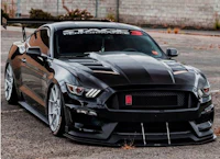 a black ford mustang gt is parked in a parking lot