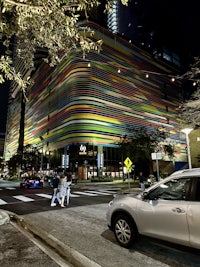 a car is parked in front of a colorful building at night