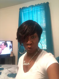a woman wearing a white shirt and hoop earrings in front of a tv