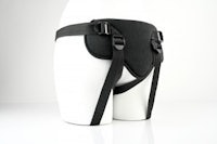 a mannequin wearing a black harness with straps