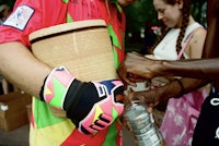 a man is handing someone a bucket of water