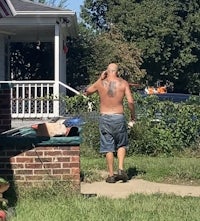 a man walking down the street with a tattoo on his back