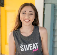 a young woman wearing a tank top that says we sweat pink