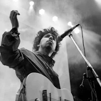 a black and white photo of a man holding a guitar