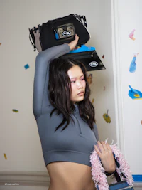 a woman is holding a bag on her head
