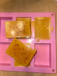 three bars of soap in a pink tray