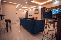 a living room with a blue couch and bar stools