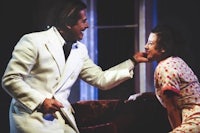 a man in a white suit and a woman in a dress