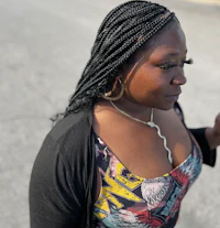 a woman with braided hair walking down the street