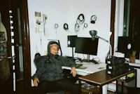 a man sitting in front of a desk with headphones on