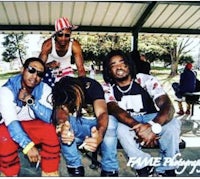 a group of men posing for a picture on a bench