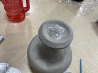 a vase is sitting on a table with paint on it