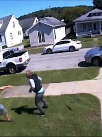 a woman is being chased by a man in a neighborhood