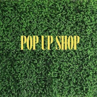 a green grass background with the words pop up shop