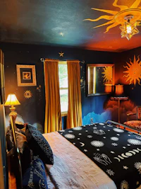 a bed in a bedroom with a sun painted on it