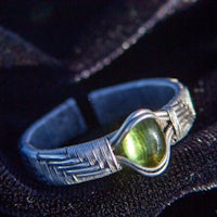 a silver ring with a green stone on it