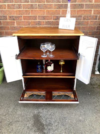 a wooden cabinet with wine glasses on it