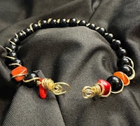 a black and orange beaded bracelet on a black background