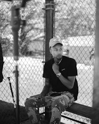 a man sitting on a bench with a baseball bat