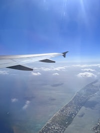 a view of the wing of an airplane flying over a city