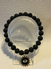 a black bracelet with an evil eye on it