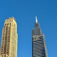 two tall buildings with a blue sky in the background