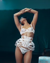 a woman in white lingerie posing in a dark room