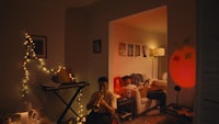 two people sitting in a room with lights on