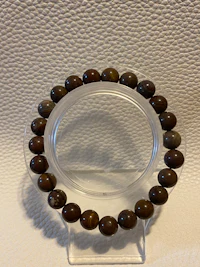 a bracelet with brown beads on a white surface