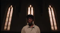 a man in a hat standing in front of a church