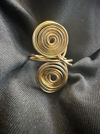 a gold spiral ring on a black cloth