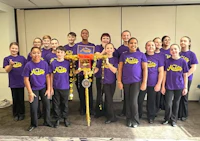 a group of people in purple shirts posing for a picture