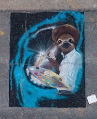 a street painting of a sloth with a paint brush
