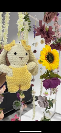 a stuffed bunny is hanging from a bunch of flowers