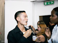 a man is talking to a woman at london fashion week