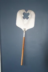a metal spatula hanging on a wall