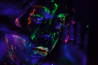 a woman with glowing paint on her face