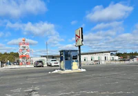 a gas station with a sign in the middle of the road