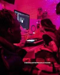a group of people sitting in front of a computer