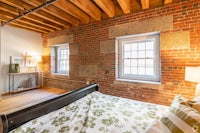 a bedroom with brick walls and a bed