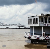 a boat on a river with a bridge in the background