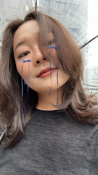 a woman with blue tear stains on her face