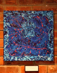 a blue and red painting on a brick wall