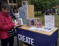 a woman looking at a table with a sign that says create