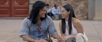 a man and a woman sitting on the ground