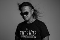 a black and white photo of a man wearing sunglasses and a t - shirt