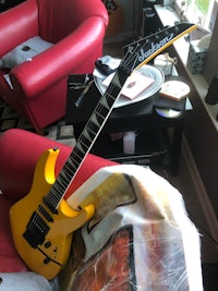 a yellow guitar sitting on a red chair