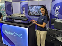 a woman standing next to a model boat at a trade show