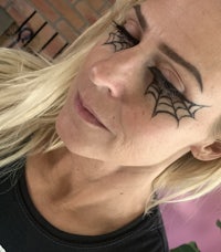 a woman with black spider webs on her eyes