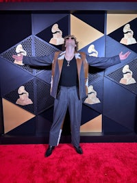 a man standing on a red carpet with his arms outstretched